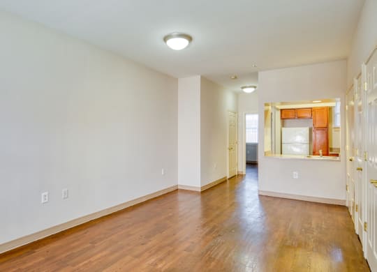 the living room and dining room of an empty house with wood floors and white walls at North Market South Carroll, Frederick Maryland