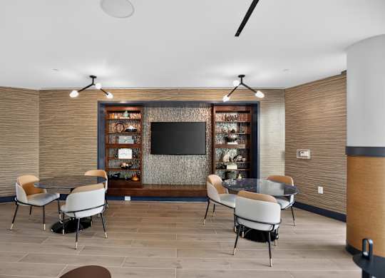 A modern dining room with a television and chairs.