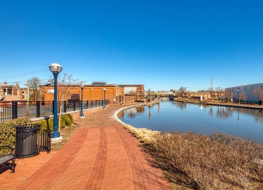 a canal with a brick walkway and buildings on the other side at North Market South Carroll, Frederick, MD 21701