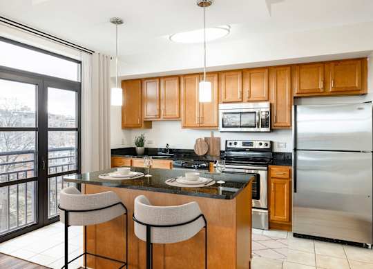 A kitchen with wooden cabinets and a black countertop. at Loree Grand at Union Place, Washington, 20002