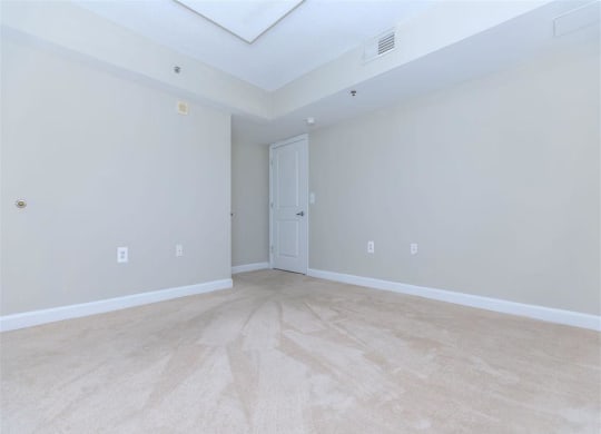 an empty bedroom with a door to a bathroom at The Gramax, Silver Spring, MD