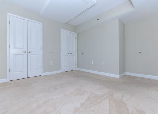 a bedroom with two doors and a carpeted floor at The Gramax, Silver Spring, MD, 20910