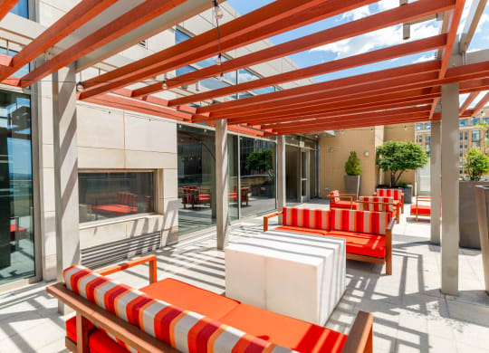 a patio with orange and white furniture and a fireplace at The Acadia at Metropolitan Park, Arlington