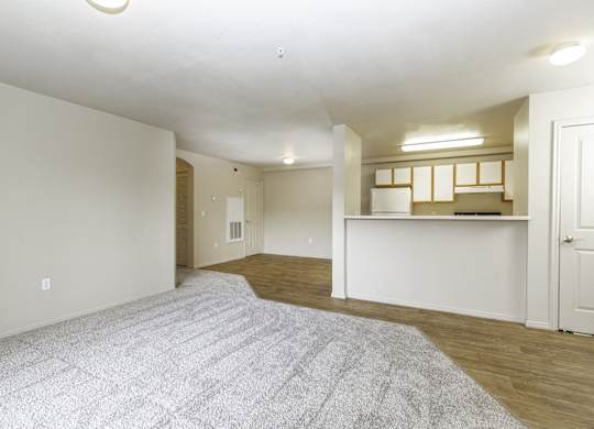 A spacious room with a grey carpet and white walls.at Sunset Ridge, West Jordan Utah