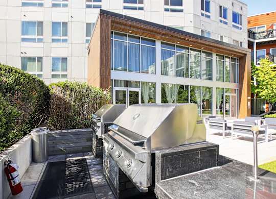 A modern building with a trash bin in front.