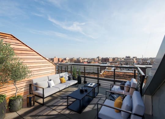 a terrace with couches and a table on a roof top  at Reed Row, Washington, 20009