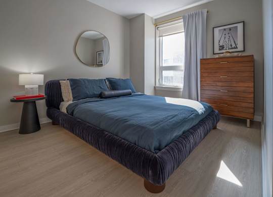 A bedroom with a large bed and a wooden headboard at Jayde Parkside Apartments, Washington DC