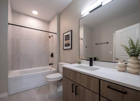A modern bathroom with a white tub, sink, and toilet at Jayde Parkside Apartments, Washington 20019