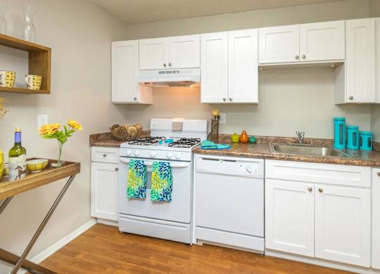 A kitchen with white cabinets and a white stove top oven.at The Pointe at Midtown, North Carolina, 27609