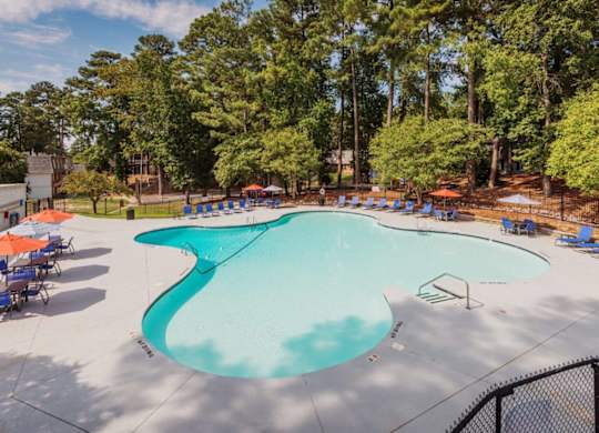 A large outdoor swimming pool surrounded by trees and lounge chairs.at The Pointe at Midtown, Raleigh North Carolina