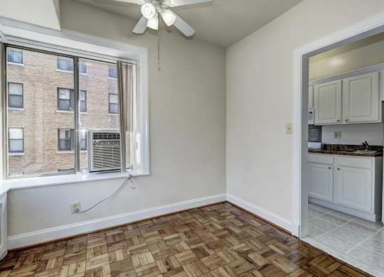 A room with a window and a ceiling fan.