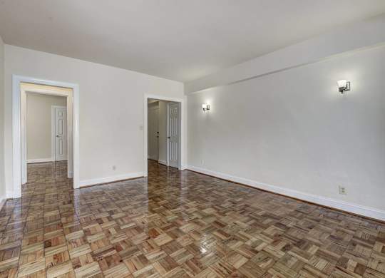A room with a wooden floor and two doors.