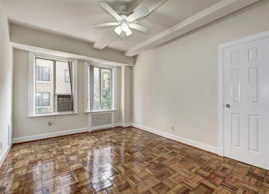 A room with a wooden floor and a ceiling fan.