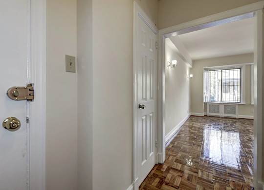 A hallway with a tiled floor and white walls.