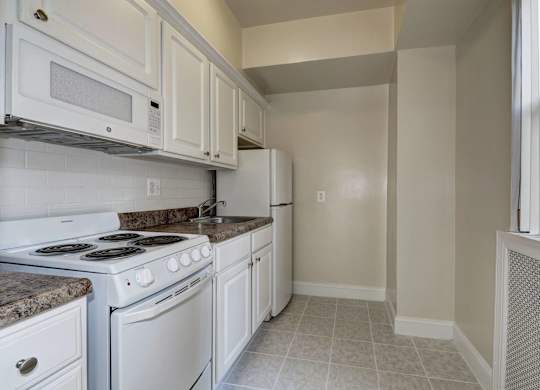 A kitchen with white appliances and cabinets.