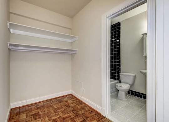 A bathroom with a toilet and a wooden floor.