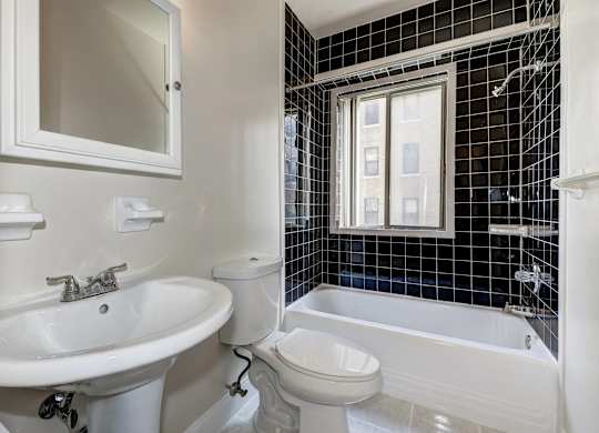 A white bathroom with a sink, toilet, and bathtub.