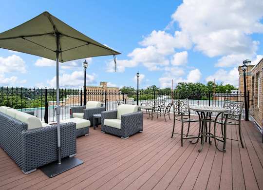 A patio with a table and chairs under an umbrella.