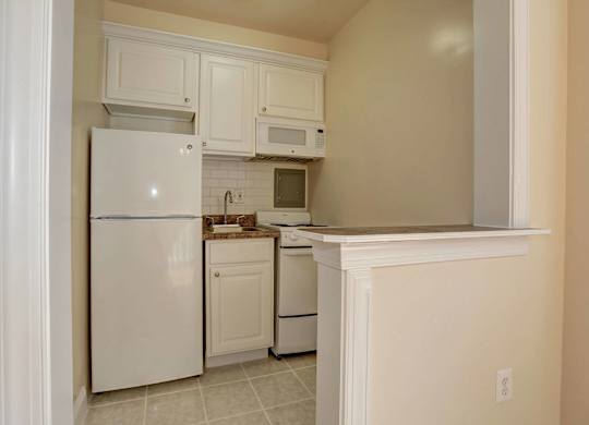 A kitchen with white appliances and cabinets.