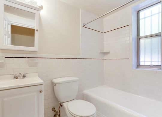 Clean bathroom with white tile and tub at Tivoli Gardens Apartments, Washington, DC 20010