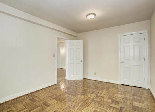 Empty bedroom with parquet floors and closet at Tivoli Gardens Apartments, Washington, 20010