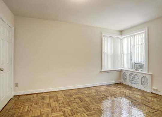 Empty bedroom with window and air conditioning unit at Tivoli Gardens Apartments, Washington