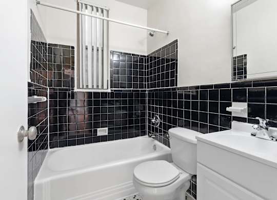 A bathroom with a white tub, toilet, and sink.