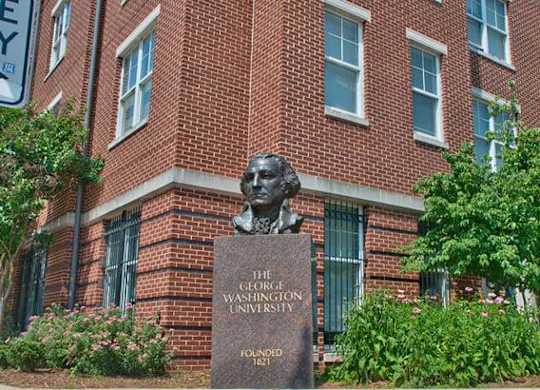 A brick building with a bust of a man and a sign that says
