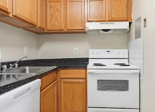 A kitchen with a white stove and white dishwasher.