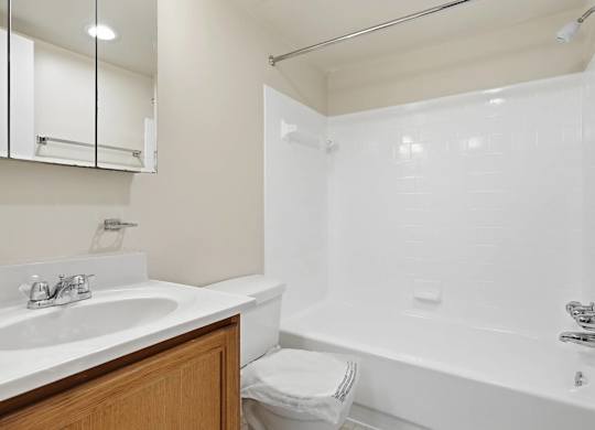 A white bathroom with a sink, toilet, and bathtub.