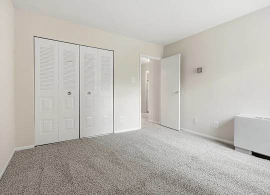 A room with white walls and a grey carpet.