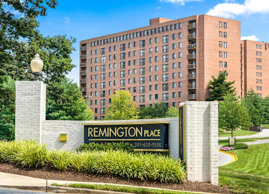 A sign for Remington Place stands in front of a building.