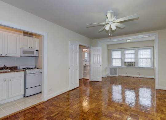 A room with a ceiling fan and wooden flooring.