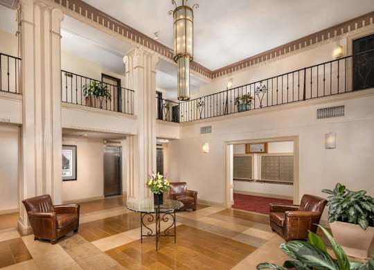 A large room with a balcony and a table with chairs.