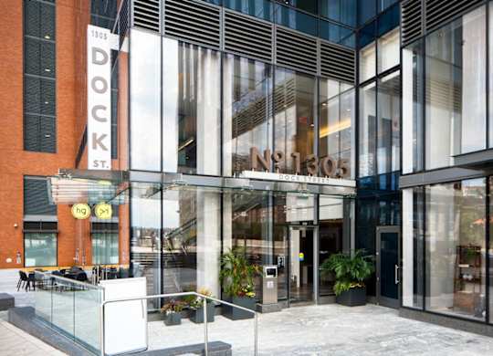 Modern glass building entrance with signage at 1305 Dock Apartments, Baltimore, Maryland