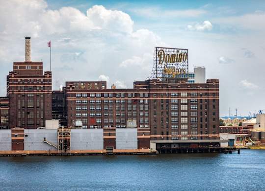 Historic brick buildings along waterfront with vintage signage at 1305 Dock Apartments, Maryland