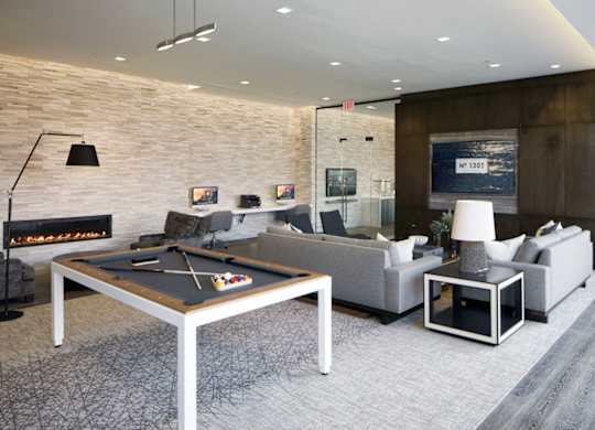 Modern lounge with pool table and fireplace at 1305 Dock Apartments, Baltimore
