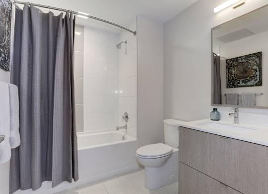 Modern bathroom with gray vanity and tub at 1405 Point Apartments, Maryland, 21231