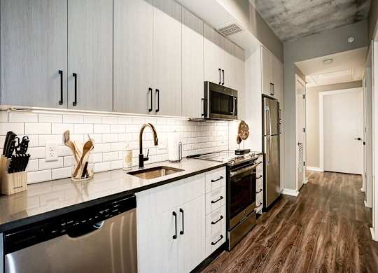 A kitchen with white cabinets and black appliances.