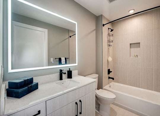 A modern bathroom with a white sink and a white toilet.