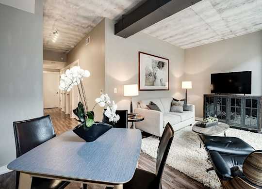 A modern dining room with a wooden table and chairs.