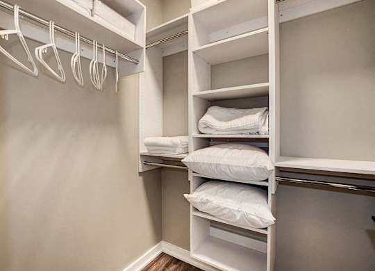 A white closet with shelves and hangers.