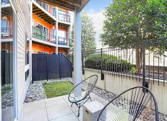 A patio with a chair and a table is shown.