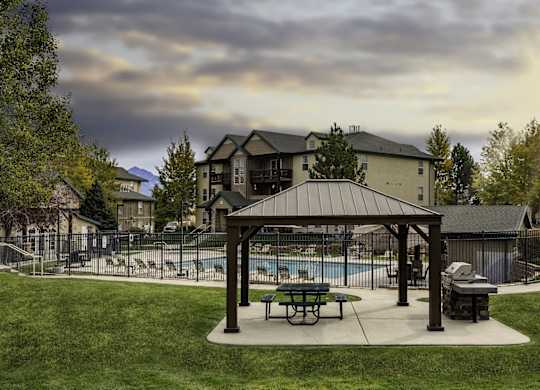A covered picnic area with a pool in the background.at Sunset Ridge, West Jordan Utah