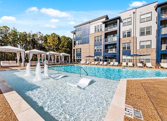 A pool with a fountain and cabanas at Preston Ridge.
