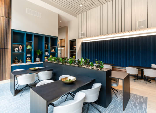 community coworking lounge with blue walls and white chairs and tables at Preston Ridge Apartments Cary, NC
