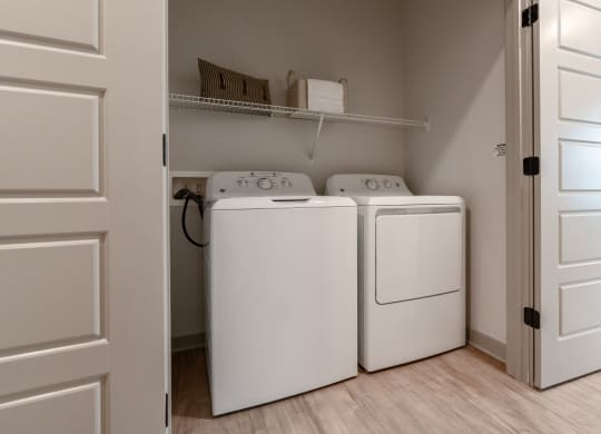 an empty laundry room with two washes and a dryer in it at Preston Ridge, Cary, NC