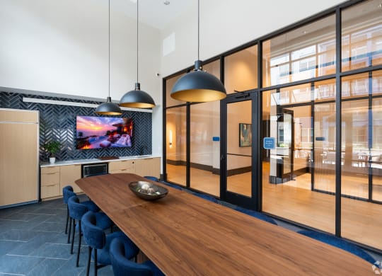 a dining room with a wooden table and blue chairs at Preston Ridge, Cary, NC