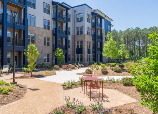 an outdoor area with a table and chairs in front of an apartment building at Preston Ridge, North Carolina