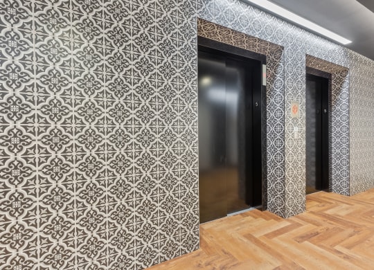 a corridor with two doors and a wooden floor and a patterned wall paper at Rialto, Washington